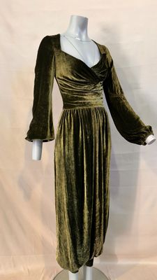 a green velvet dress on a mannequin base with a white mannequin torso