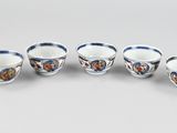 six cups and saucers with butterflies on them on a table