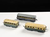 trois trains miniatures posés sur une table l'un à côté de l'autre