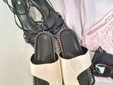 pair of black and white sandals and a purse on a table