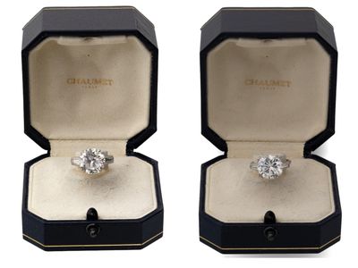 une paire de bagues de fiançailles en diamant dans un coffret noir sur fond blanc
