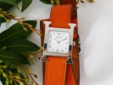 an image of a watch with a leather band and a flower on a white surface