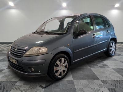 a picture of a small grey car parked in a garage