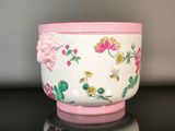 a white bowl with pink flowers on it on a table