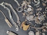 a lot of silver jewelry on a black surface