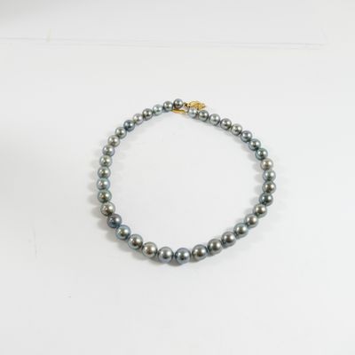 un gros plan d'un bracelet de perles posé sur une surface blanche