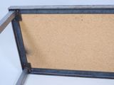 a metal frame with a cork board inside of it