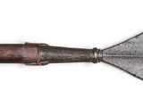 an old metal arrow with a wooden handle on a white surface
