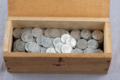 a box full of silver coins sitting on a table