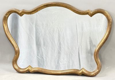 a gold framed mirror sitting on top of a white table