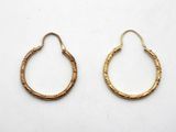 une paire de boucles d'oreilles en or sur fond blanc