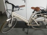a white bicycle parked in a garage next to a white door