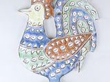 une sculpture en céramique représentant un coq sur un fond blanc