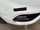 a sticker that says caution on the front of a white car