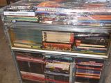 a man that is standing behind a cart full of dvds
