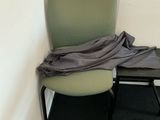 a green chair with a blanket on it in a room
