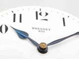 a white clock with black numbers on it on a table