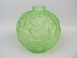 a green glass vase that is sitting on a white surface