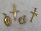 three gold crosses, a heart, and a cross on a table