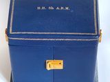 an old blue box with a brass lock on a white surface