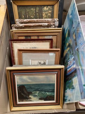 de nombreuses œuvres d'art encadrées posées sur une étagère dans une pièce