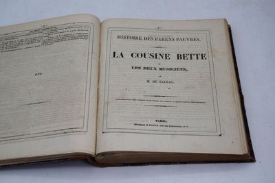 un livre ouvert posé sur une table, sur fond blanc
