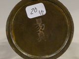 a small metal object with a chinese writing on it