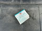 a small piece of paper on the ground next to a parking meter