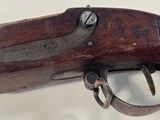 an old gun with a wooden handle on a white surface