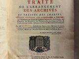 un livre ouvert posé sur une table, à côté d'une feuille de papier
