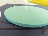someone is pouring something into a yellow cup on top of a table