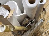 several rolls of toilet paper are in a shopping cart on the floor