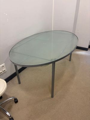 a glass table with a chair in the corner of the room