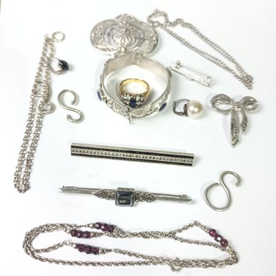 a lot of silver jewelry on a white surface
