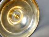 un vase en argent posé sur une table, sur fond blanc
