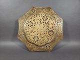 an antique brass plate with a decorative design on it