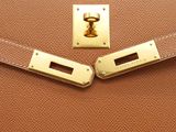 a close up of a brown leather purse with a gold lock