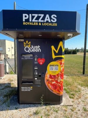 un distributeur automatique sur lequel est posée une pizza