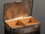 a small metal box with two compartments on a table