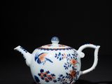 a blue and white teapot with a floral design on it