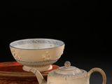 deux tasses et une soucoupe posées sur une assiette à fond noir