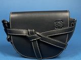 the small black leather purse is on a blue surface