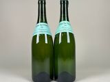 two bottles of wine sitting next to each other on a table