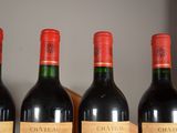 three bottles of red wine are lined up on a shelf