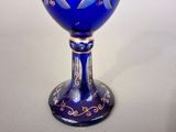 a blue goblet sitting on a table with a white background