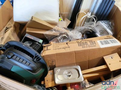 une boîte en carton remplie d'objets hétéroclites dans une pièce