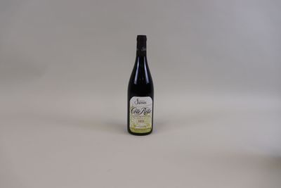 une bouteille de vin posée sur une table blanche