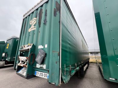 two large green semi trucks parked next to each other