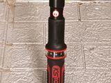 a black and red umbrella with a red handle on a sidewalk