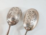 two spoons that are sitting on a table
